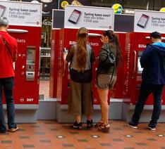 Mennesker køber billetter i billetautomater på station