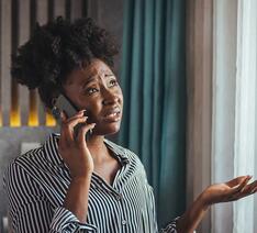 Kvinde taler i mobiltelefon og ser uforstående ud i ansigtet